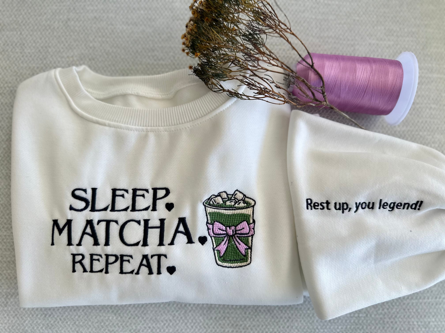 White sleeveless top with text and graphics on a neutral background. handcrafted, cozy, unique. custom embroidery