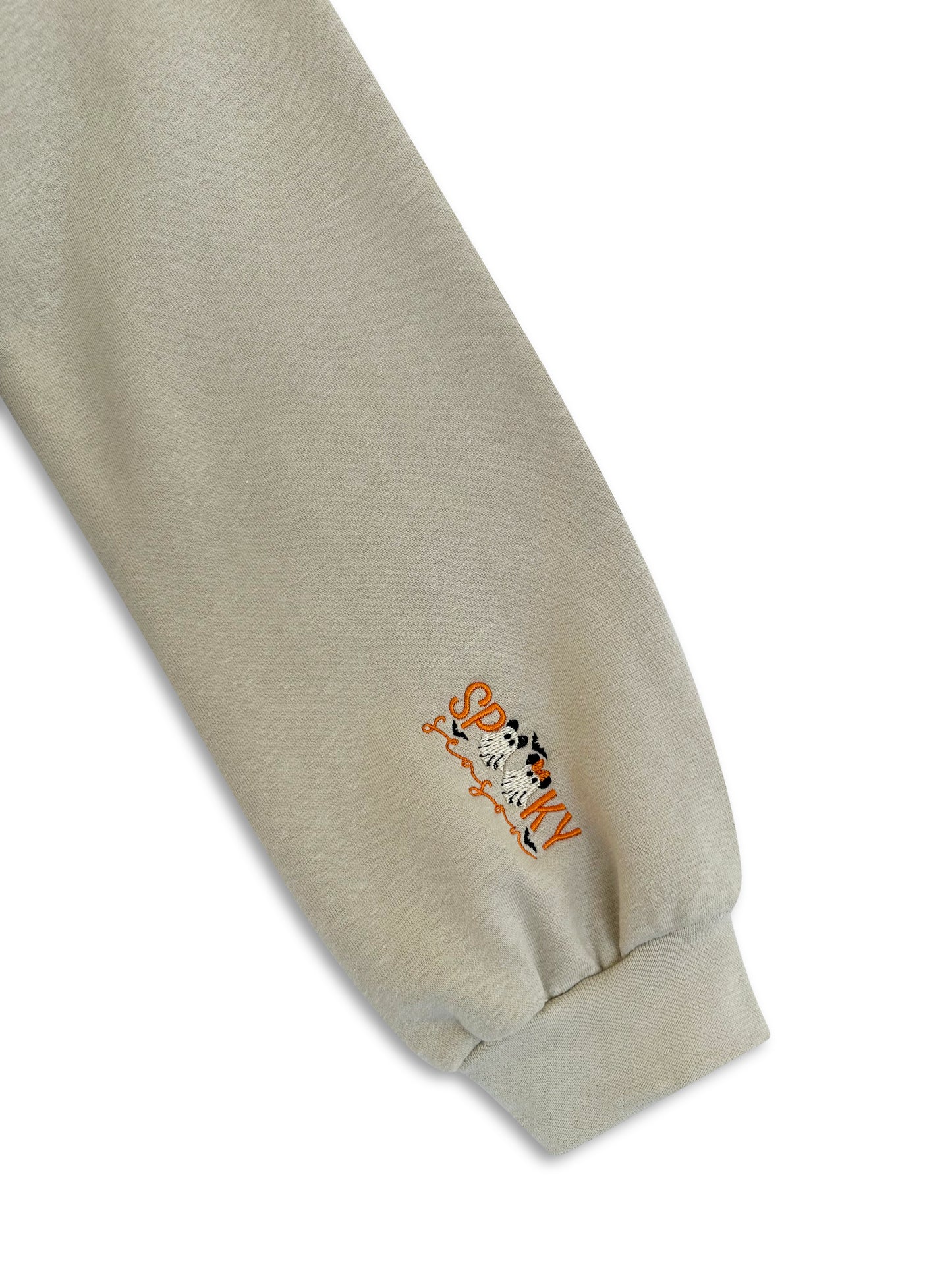 Close-up of a beige sweatshirt sleeve with an embroidered design on a white background. inclusive sizes embroidered apparel
oversized unisex embroidered hoodies
mental health message clothing
worldwide shipping embroidered garments
empowering embroidered clothing