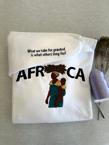 Folded white tote bag with 'AFRICA' text and graphic on a gray surface. Work logo embroidery Brisbane
