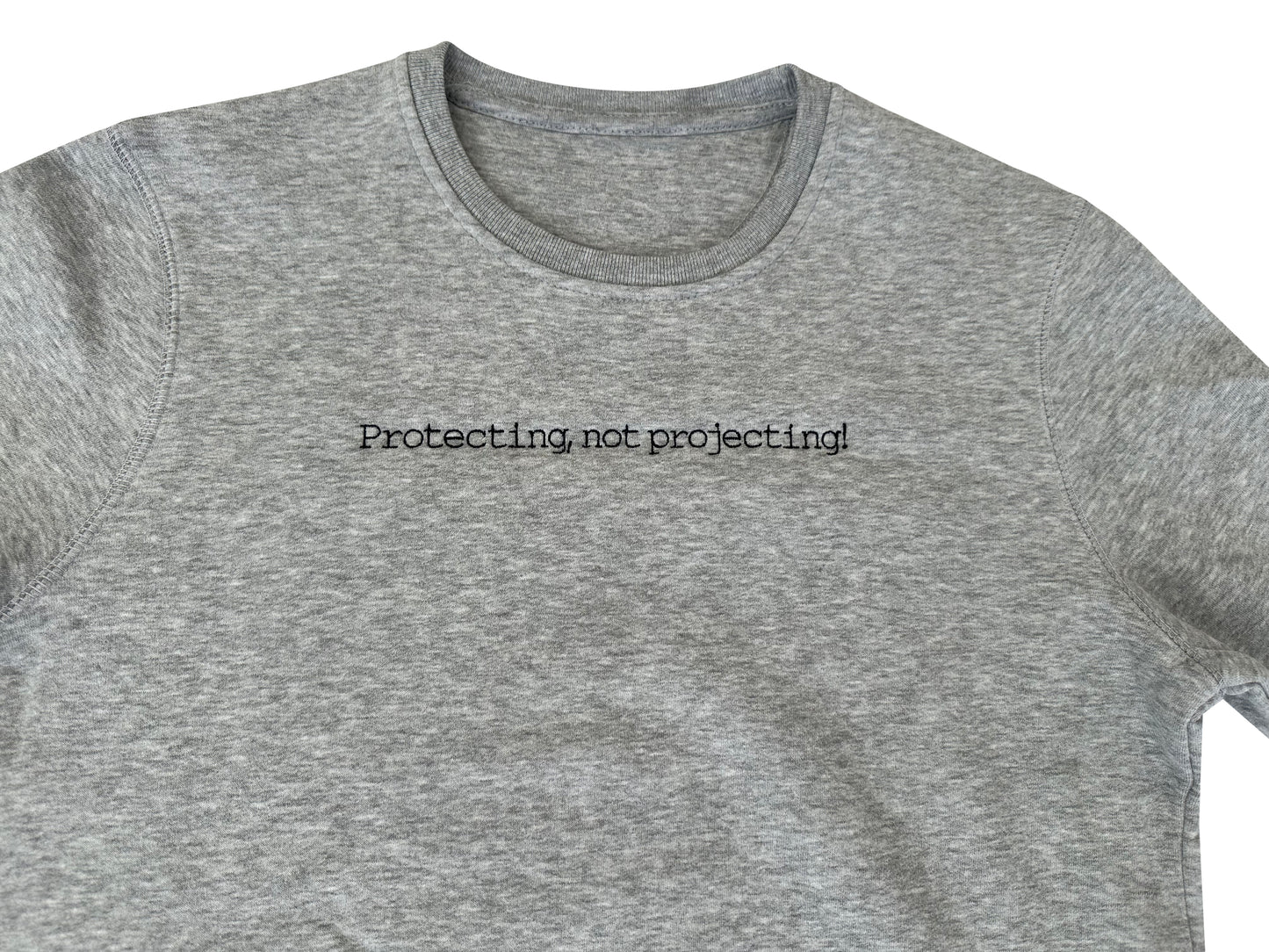Gray t-shirt with 'Protecting not projecting' text on a white background